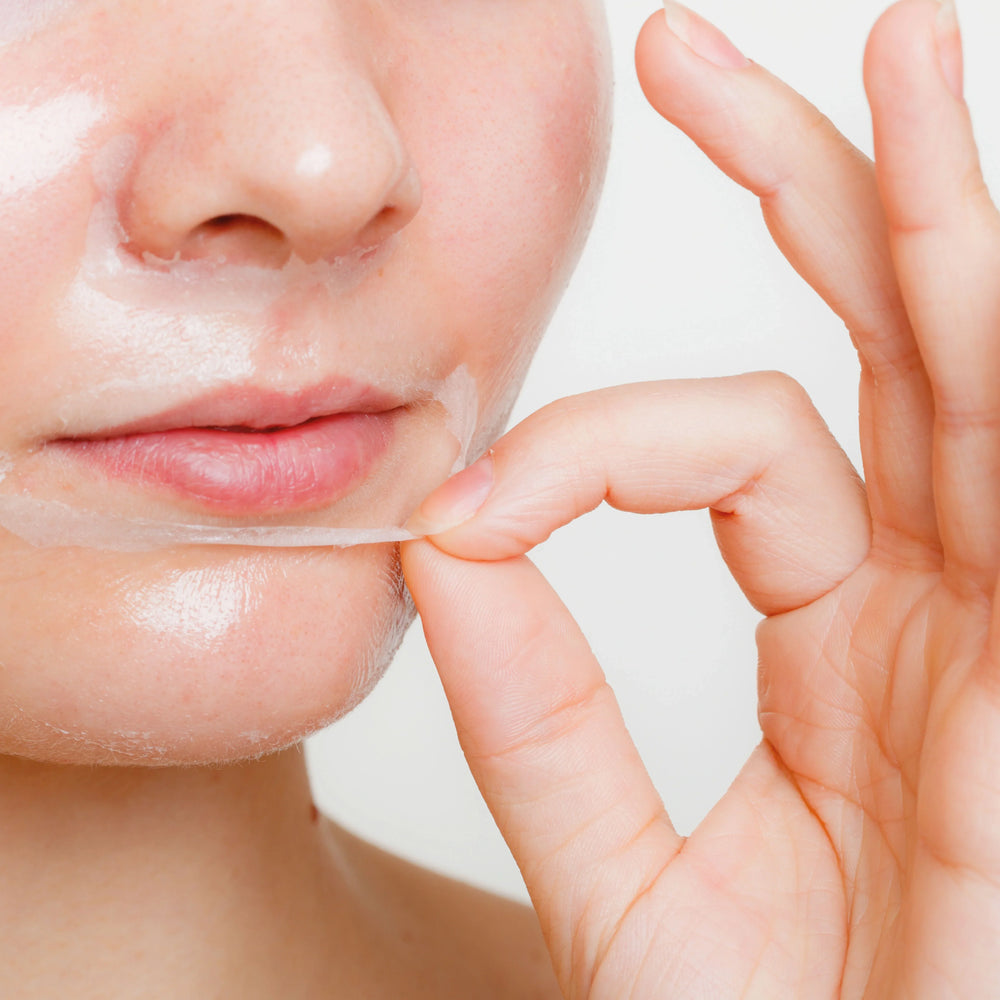 Närbild av kvinna som tar av sig ansiktsmask.