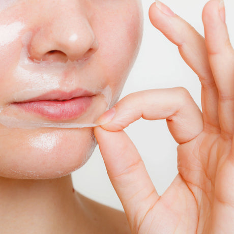 Närbild av kvinna som tar av sig ansiktsmask.