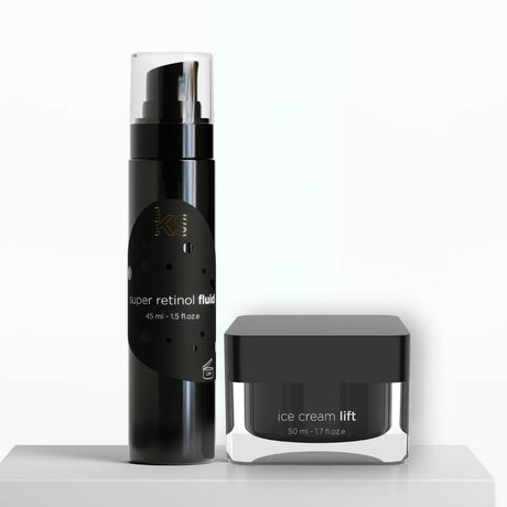 Två hudvårdsprodukter i svarte förpackningar med vit text, stående i vinkel på ljus bakgrund – anti-age-duo anpassad för normal till fet hud