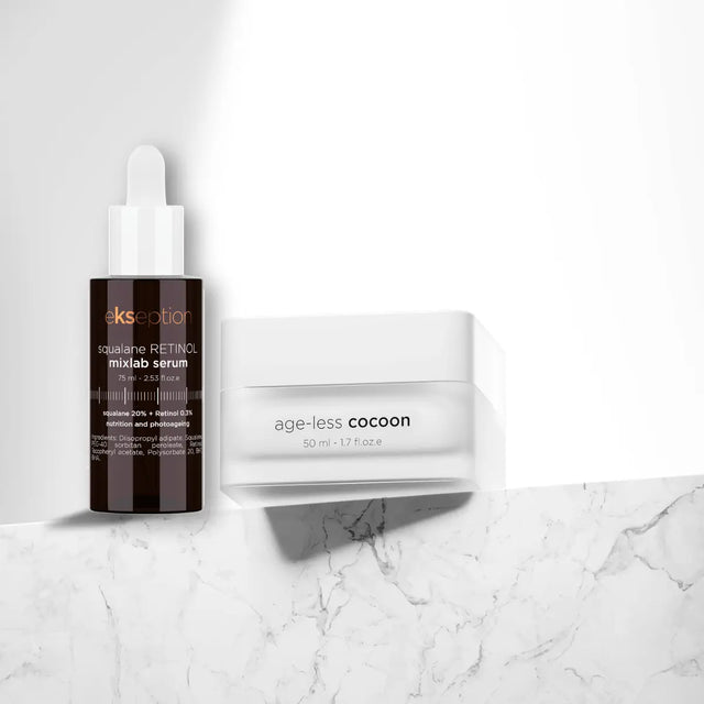 Två hudvårdsprodukter i vita förpackningar med svart text, placerade snett mot varandra på ljus bakgrund – anti-age-duo för torr till normal hud