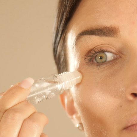 Närbild av produkten när en kvinna applicerar den i ansiktet.