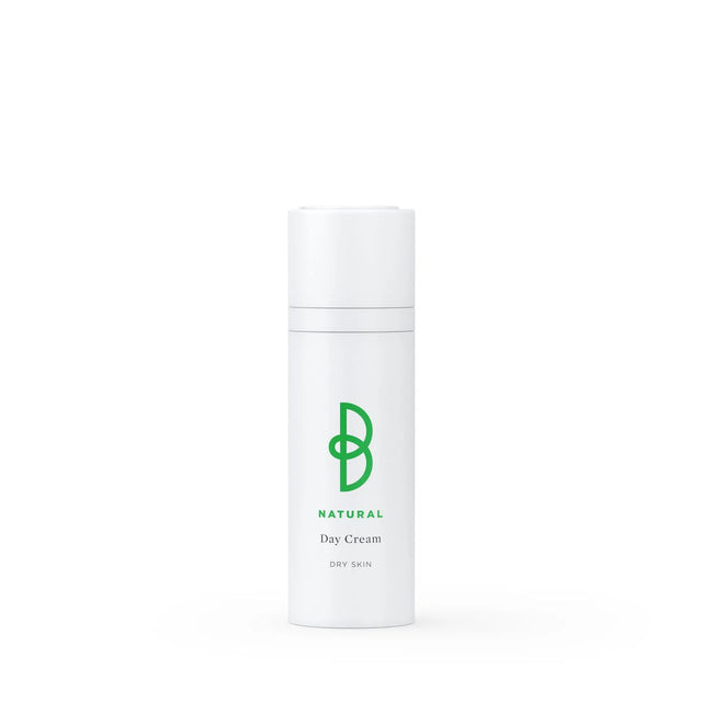 Vit tub med svart text, stående på ljus bakgrund – en dagkräm för torr hud som minskar rynkor och ger näring och lyster.