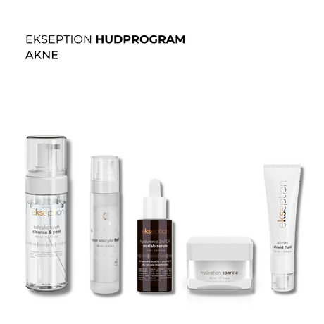 Fem hudvårdsprodukter i vita förpackningar för aknebenägen hud – rengöring, serum, kräm och exfoliering, uppradade diagonalt på beige bakgrund