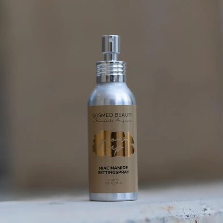 Silverfärgad sprayflaska med brun etikett,