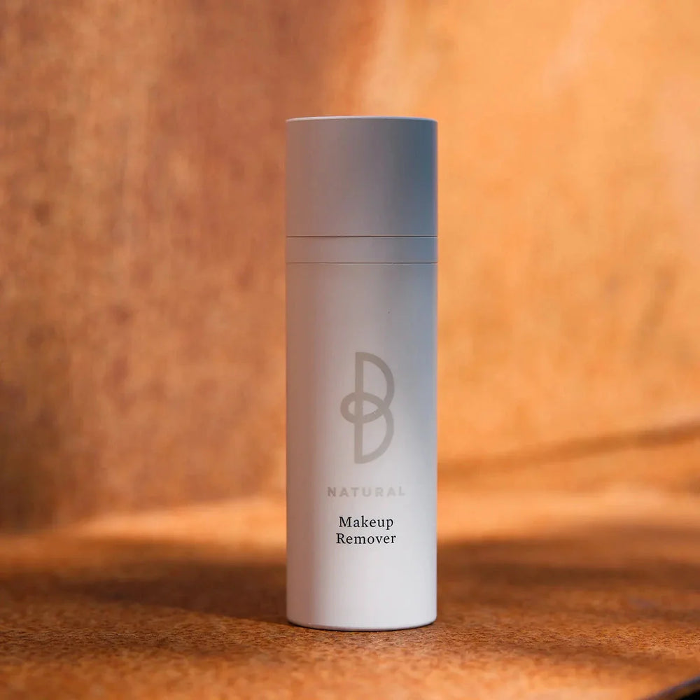 Vit flaska med svart text, stående på mörk bakgrund – en rengöringsprodukt som ger en fräschare hud och stödjer hudens naturliga barriär.