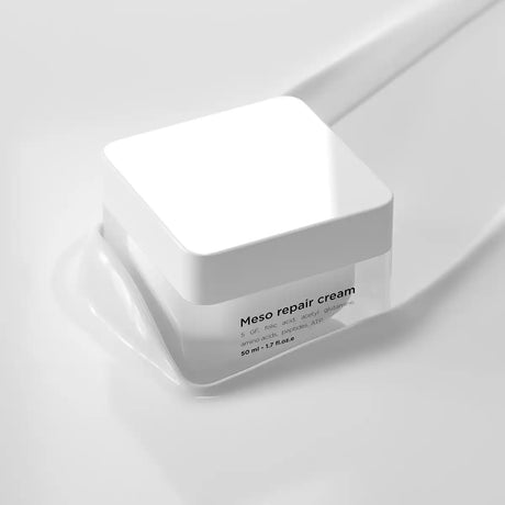 Vit burk med svart text, stående på ljus bakgrund – en antiinflammatorisk kräm som lugnar och reparerar huden.