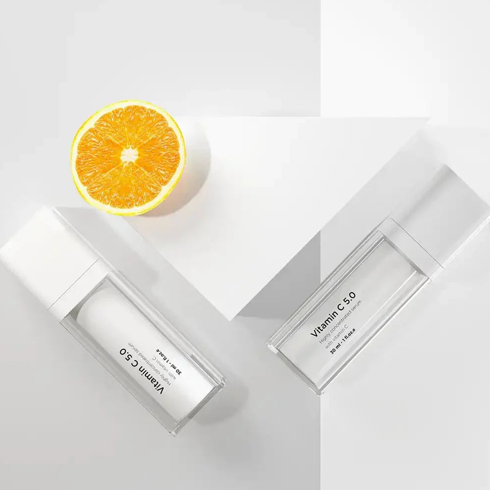 Vit flaska med svart text, stående på ljus bakgrund – ett serum som skyddar mot fotoåldring och stärker huden.