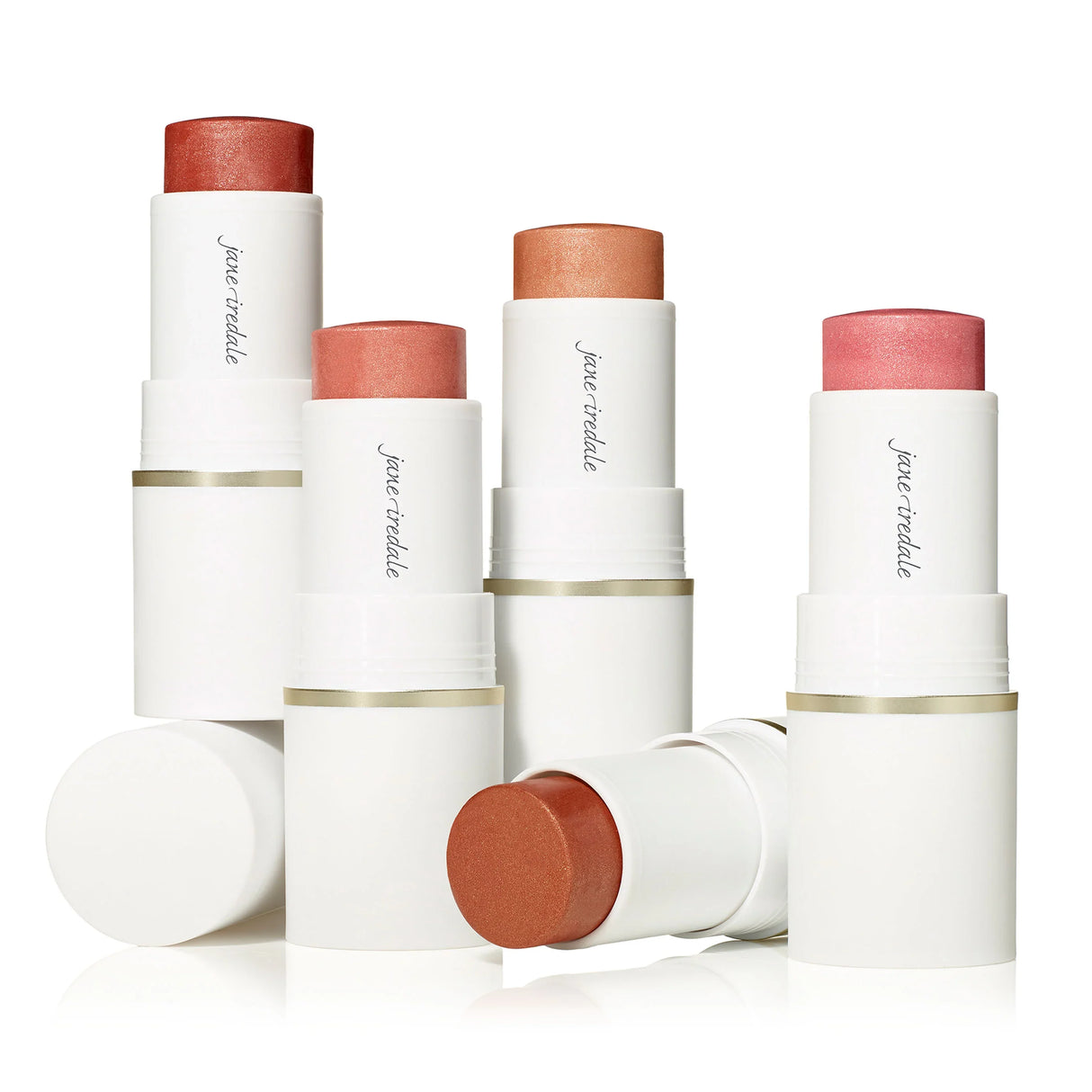Gruppbild på flera blush sticks i olika färger, visas stående med locken av, framhäver krämig textur.