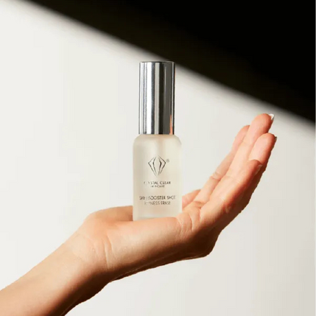 Vit flaska med svart text, stående på ljus bakgrund – en booster som lugnar huden, reducerar rosacea och förbättrar hudens klarhet.